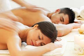 Man and woman being massaged next to each other laying face down